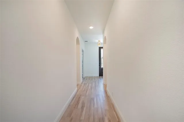 a view of a hallway with wooden floor