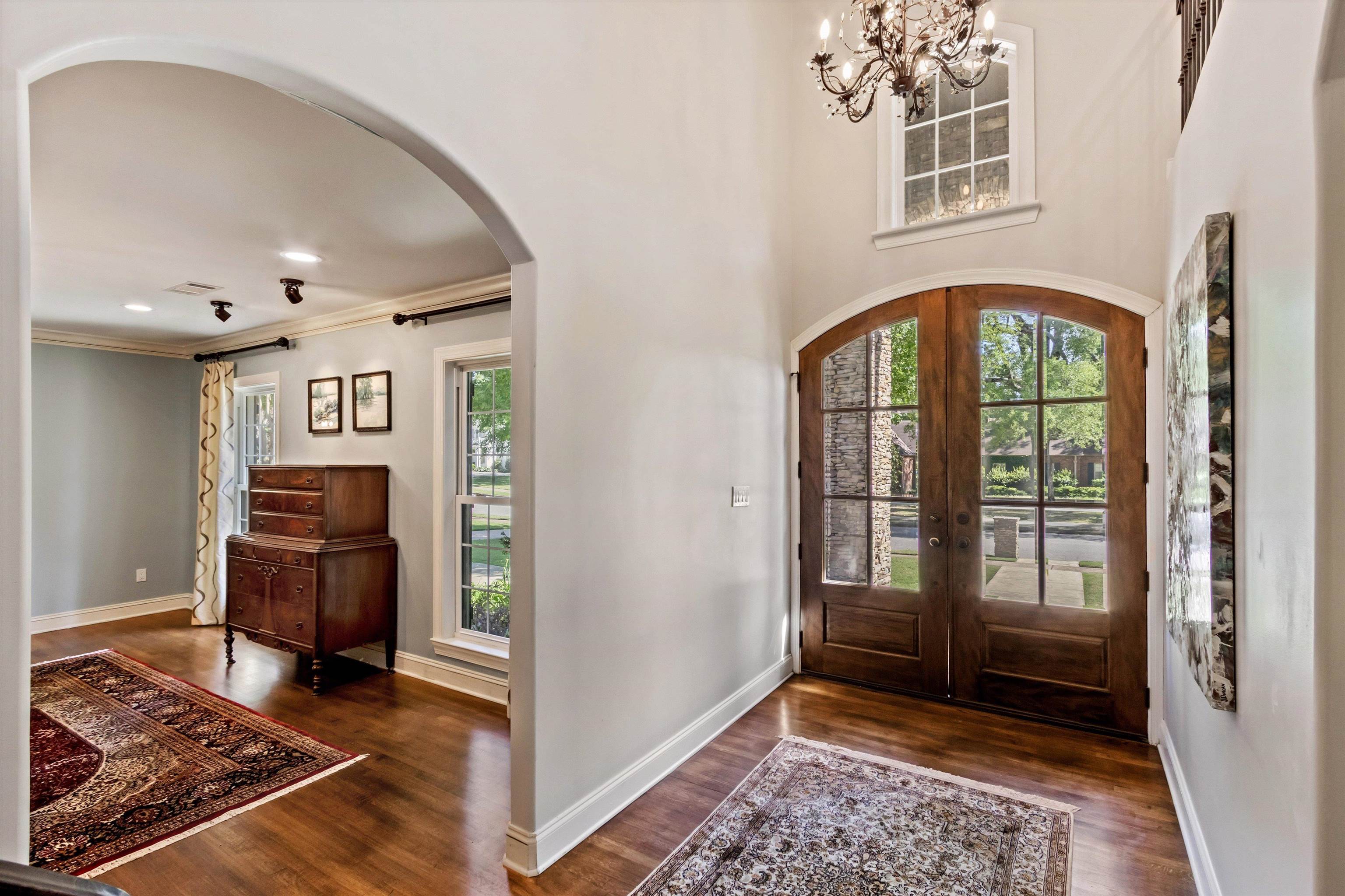 5302 South Angela Road Memphis, TN 38120 - Photo 6 of 40 Grand entryway featuring arched double doors with glass panels, a transom window, and a decorative chandelier
