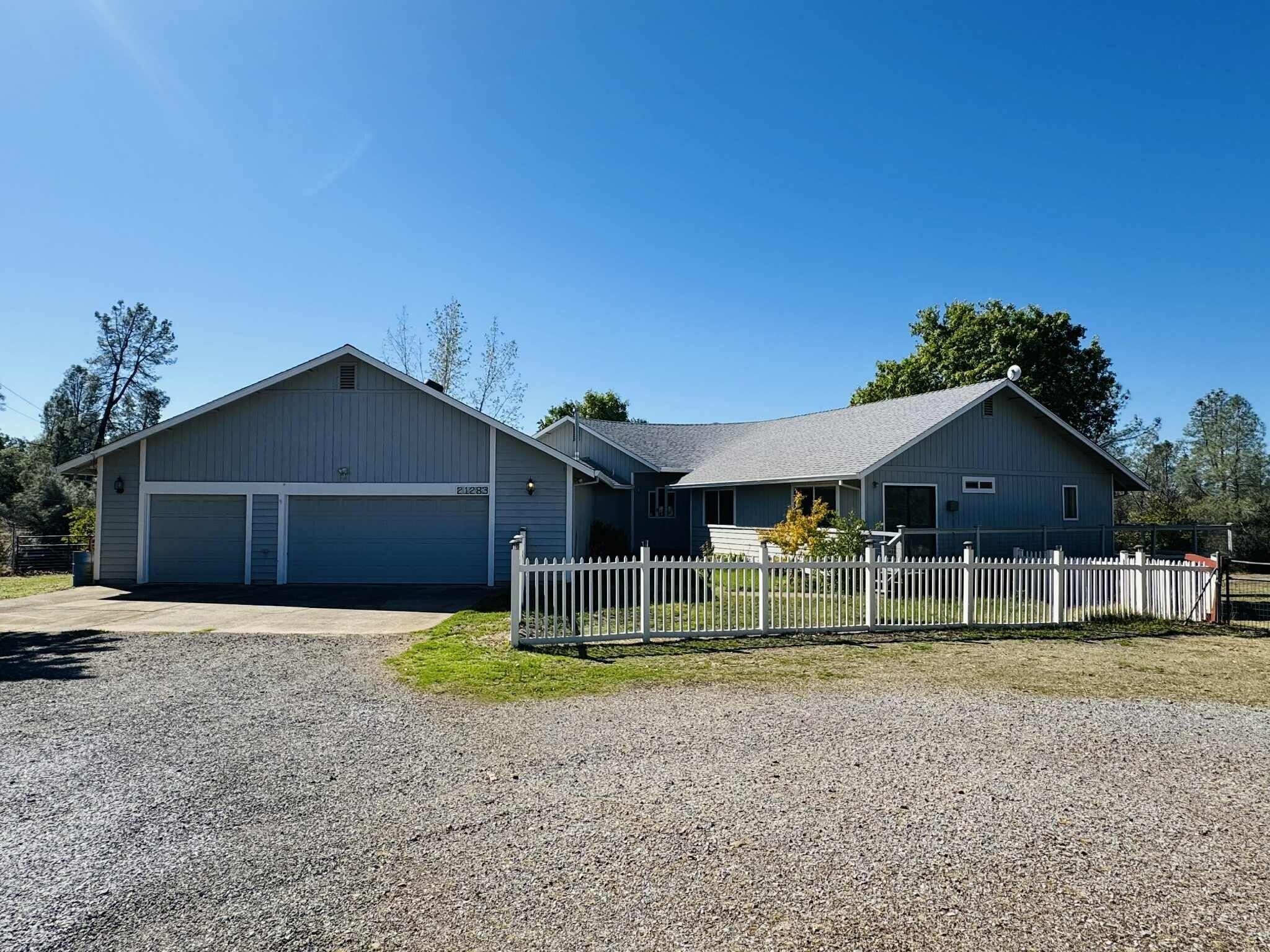 21283 Lela Lane Redding, CA 96003 - Photo 1 of 23 a front view of a house with a yard and garage