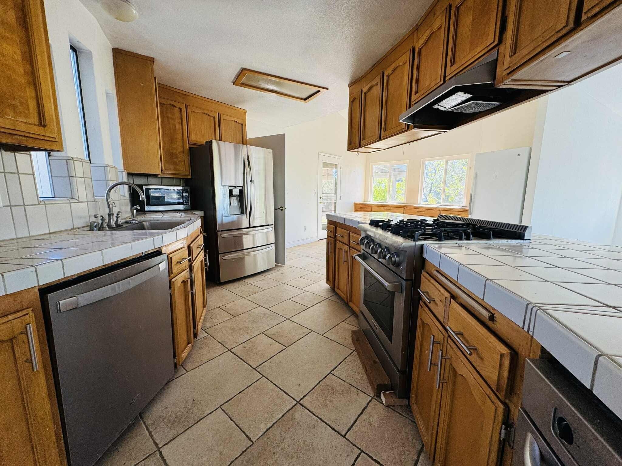 21283 Lela Lane Redding, CA 96003 - Photo 10 of 23 a kitchen with stainless steel appliances granite countertop a sink stove and refrigerator