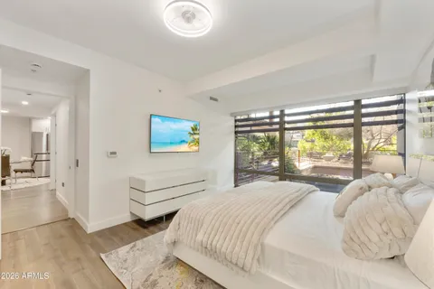 a bedroom with a balcony a bed and a large window