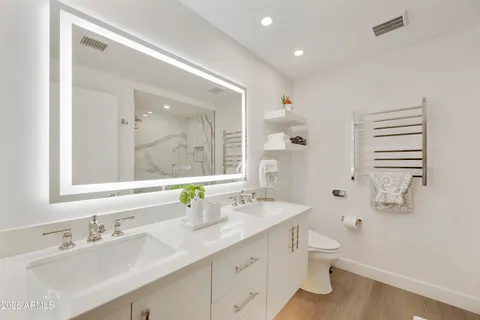 a bathroom with a double vanity sink mirror and toilet