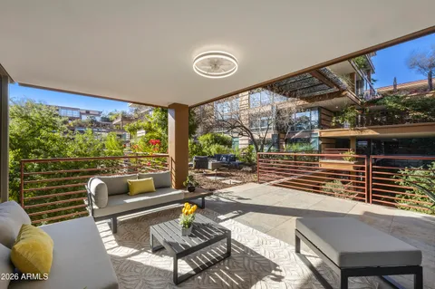 a living room with patio furniture and a floor to ceiling window