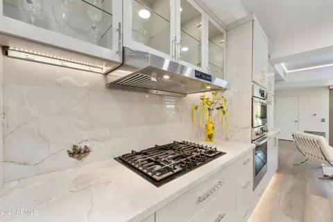 a kitchen with a stove a sink and cabinets