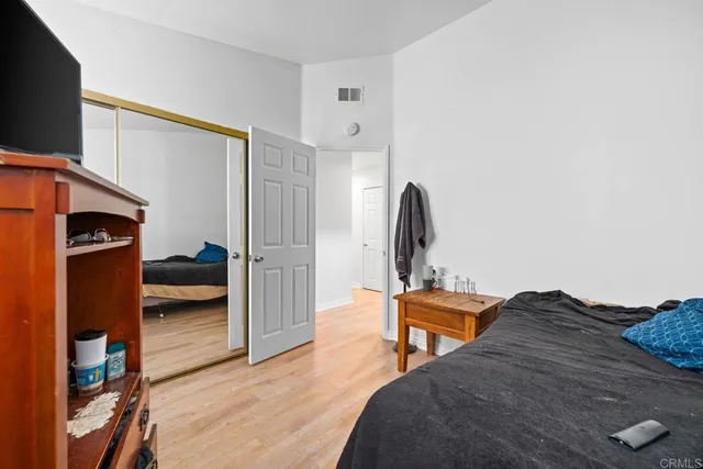 a bedroom with a bed and a flat tv screen on wall