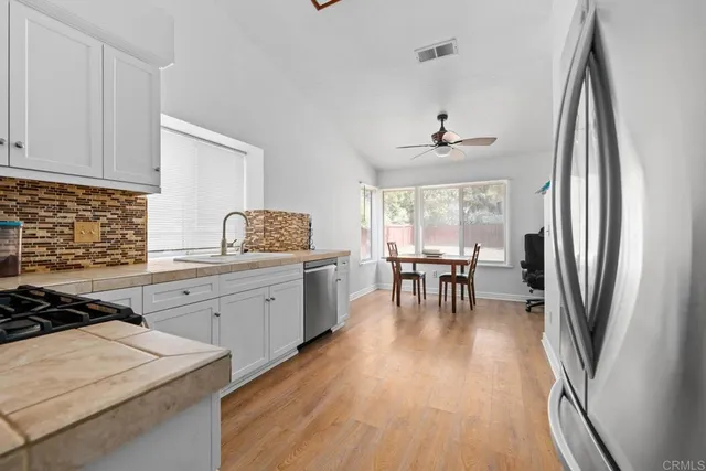 a kitchen with sink refrigerator and cabinets
