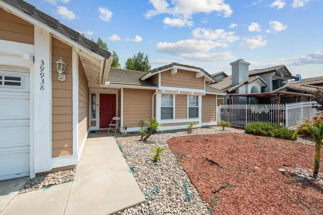 a front view of a house with a yard and potted plants