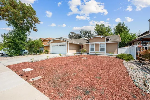 a front view of house with yard and trees around