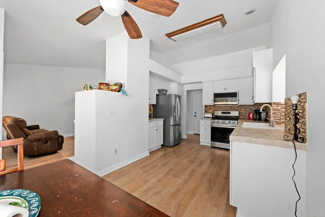 a kitchen with a refrigerator and white cabinets