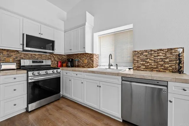 a kitchen with stainless steel appliances granite countertop a stove and a sink