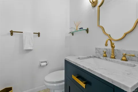 a bathroom with a granite countertop sink a toilet and with mirror