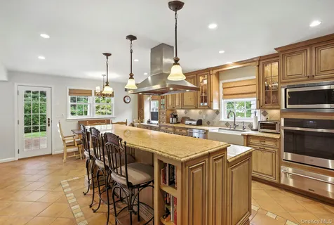 a kitchen with stainless steel appliances granite countertop a sink a stove and a refrigerator with wooden floor