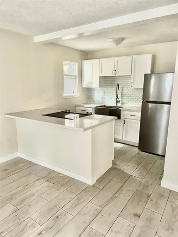 a kitchen with a stove a refrigerator and a sink