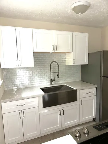 a kitchen with white cabinets sink and white appliances