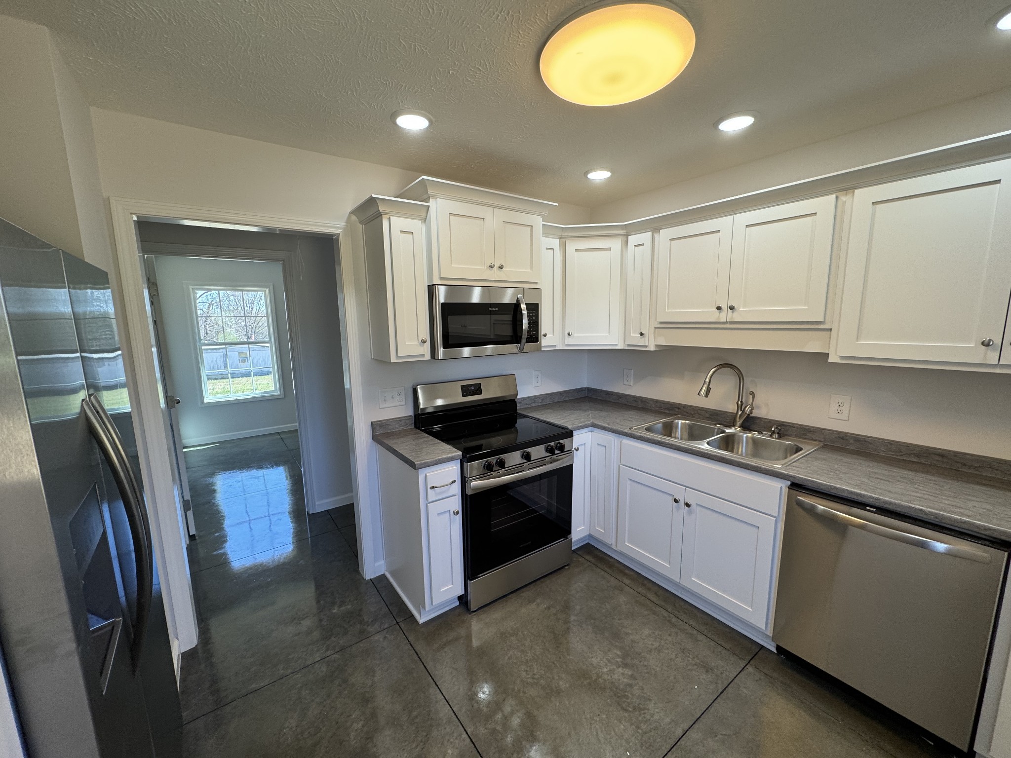 111 White Lane Portland, TN 37148 - Photo 3 of 9 a kitchen with stainless steel appliances granite countertop a stove top oven a sink and a refrigerator