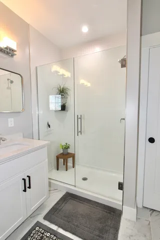 a bathroom with a shower a sink and a mirror