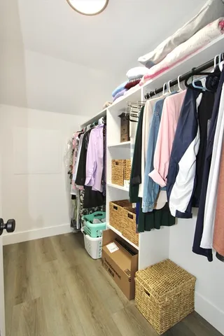 a view of walk in closet with clothes and shoes
