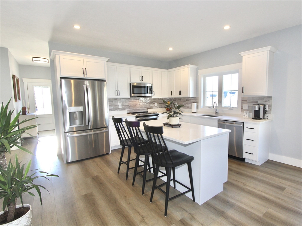 10 Salisbury Hill Boulevard, Unit 75 Worcester, MA 01609 - Photo 6 of 29 a kitchen with stainless steel appliances a dining table chairs a refrigerator and cabinets