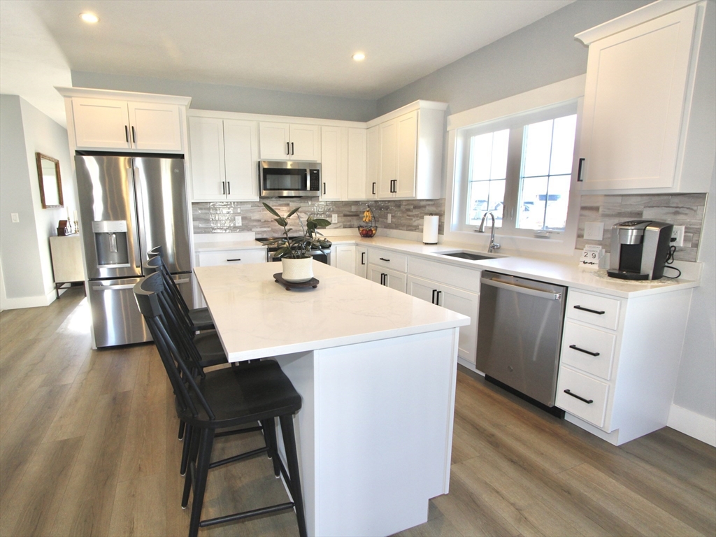 10 Salisbury Hill Boulevard, Unit 75 Worcester, MA 01609 - Photo 7 of 29 a kitchen with a sink a stove a refrigerator and white cabinets