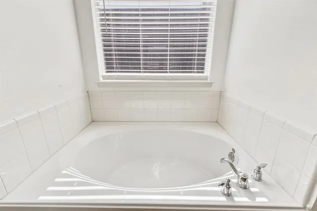a white bath tub sitting in a bathroom next to a window