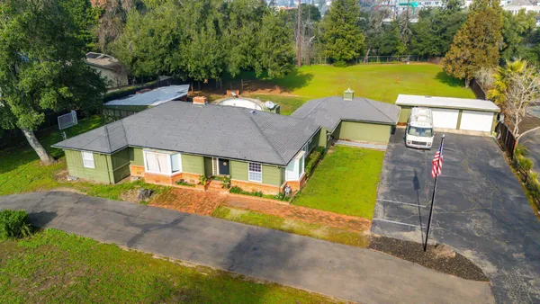an aerial view of a house with swimming pool garden and patio