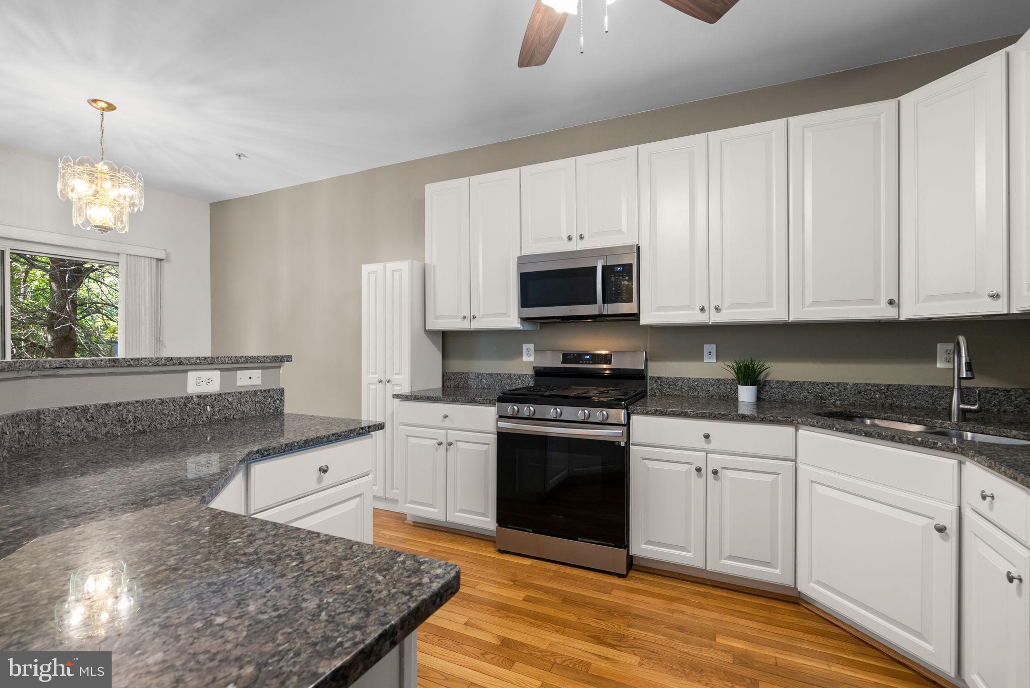 6710 Tranquil Way Elkridge, MD 21075 - Photo 8 of 49 a kitchen with stainless steel appliances granite countertop a stove a sink and a white cabinets