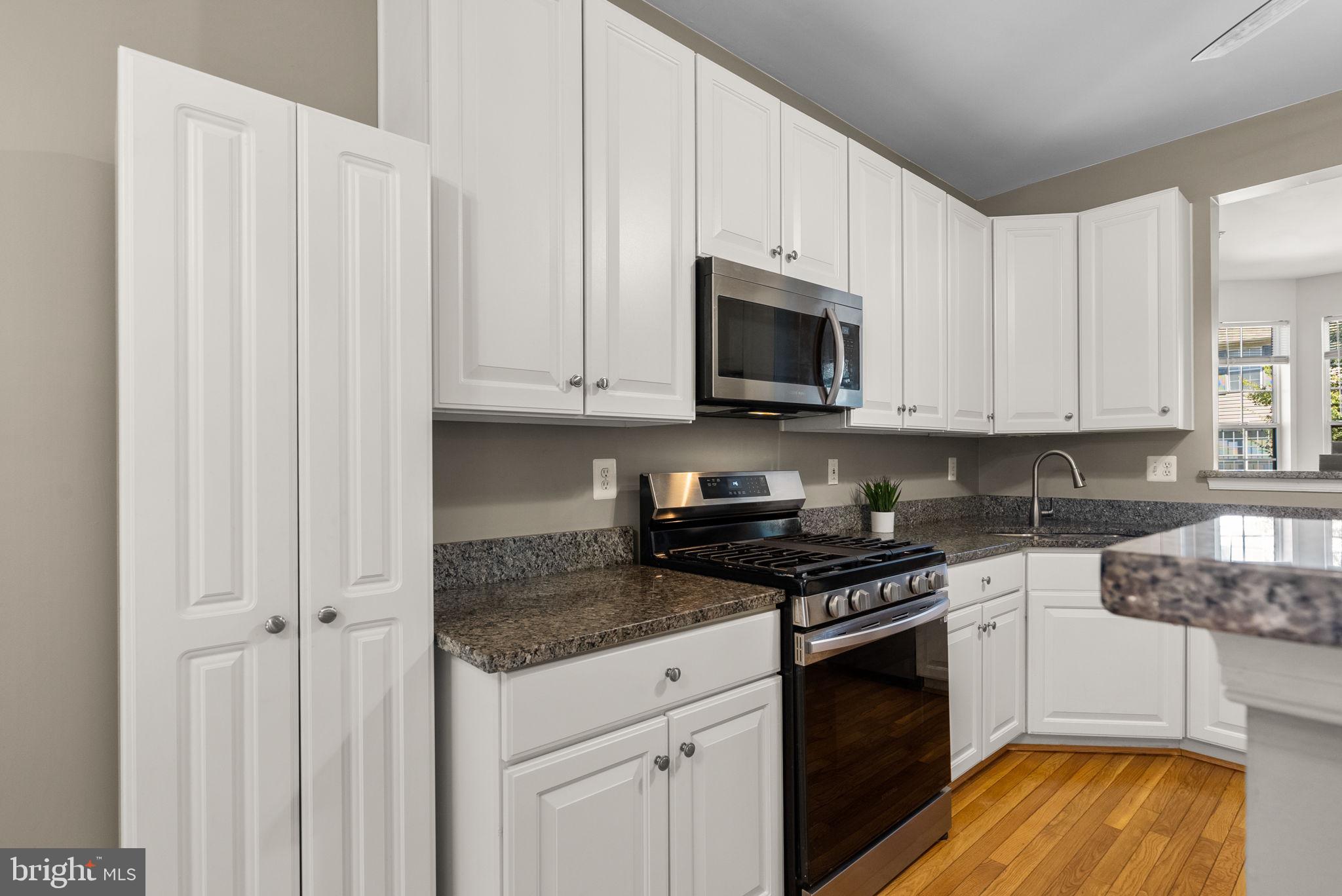 6710 Tranquil Way Elkridge, MD 21075 - Photo 9 of 49 a kitchen with granite countertop white cabinets and stainless steel appliances