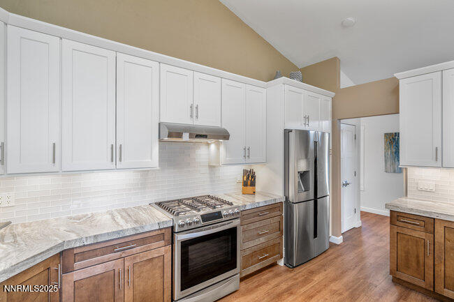 2522 Lake Ridge Shores Circle Reno, NV 89519 - Photo 14 of 50 a kitchen with stainless steel appliances granite countertop a stove a refrigerator and a white cabinets
