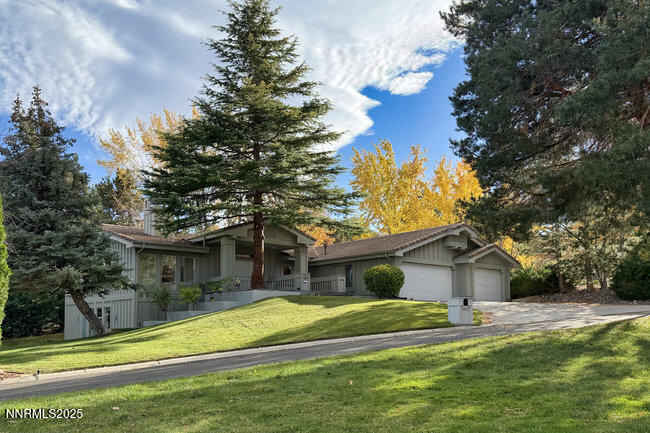 2522 Lake Ridge Shores Circle Reno, NV 89519 - Photo 4 of 50 a front view of a house with a yard and trees