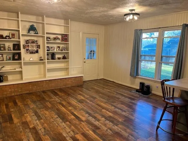 a kitchen with stainless steel appliances a table chairs and wooden floor