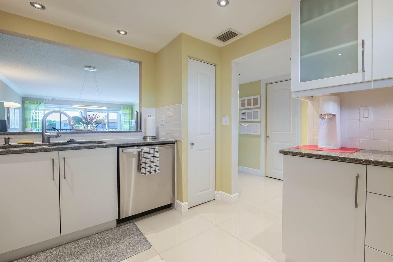 3930 Inverrary Boulevard, Unit 603D Lauderhill, FL 33319 - Photo 22 of 74 a kitchen with stainless steel appliances granite countertop a sink and cabinets