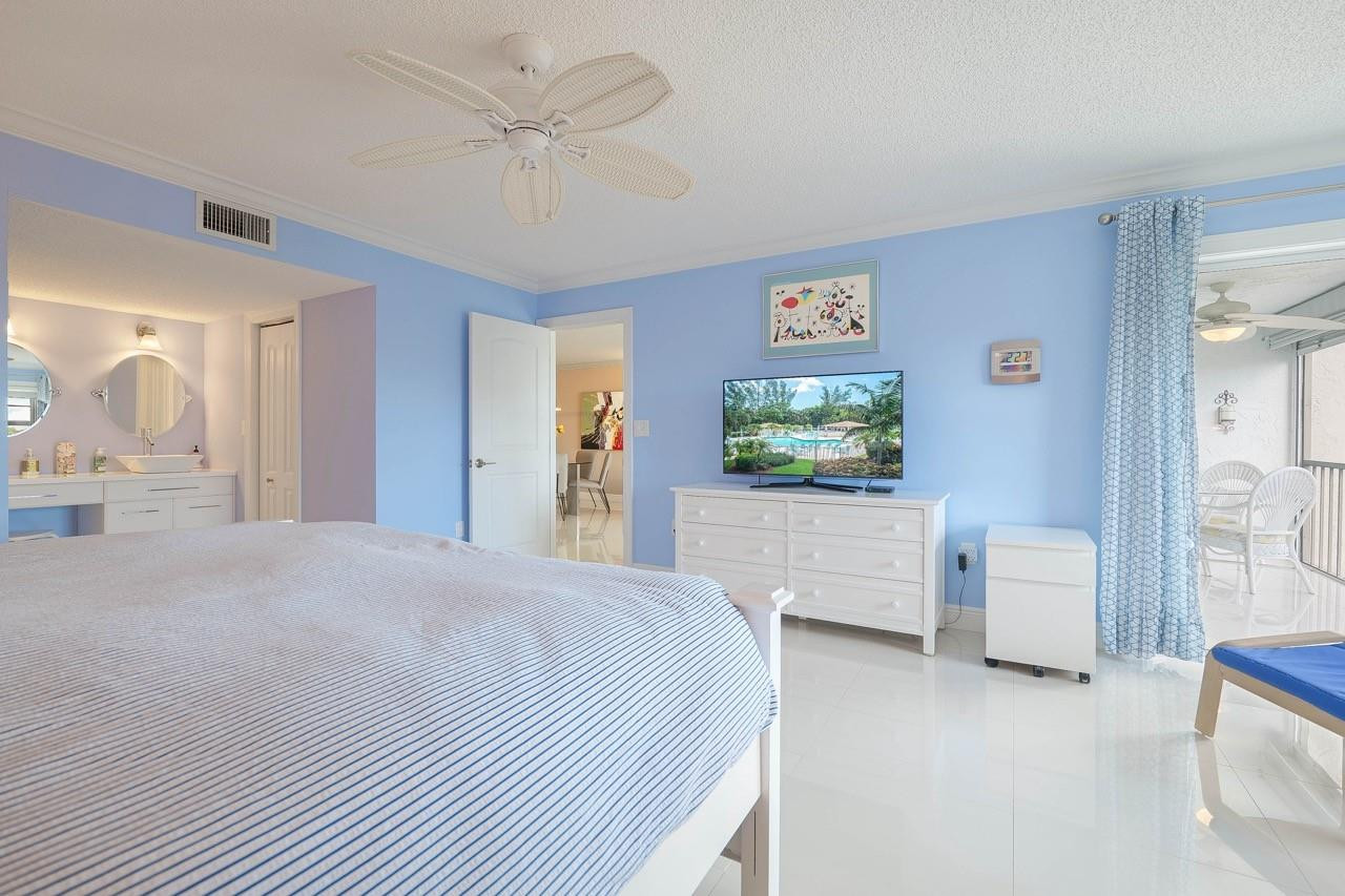 3930 Inverrary Boulevard, Unit 603D Lauderhill, FL 33319 - Photo 27 of 74 a bedroom with a white bed and a flat screen tv