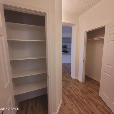 a view of a hallway with wooden floor and closet