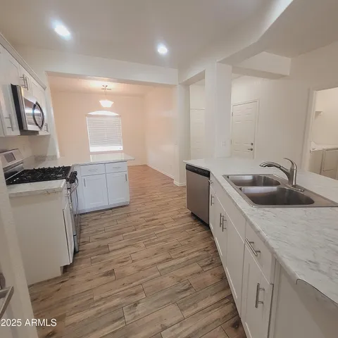 a kitchen with granite countertop a sink and a stove top oven