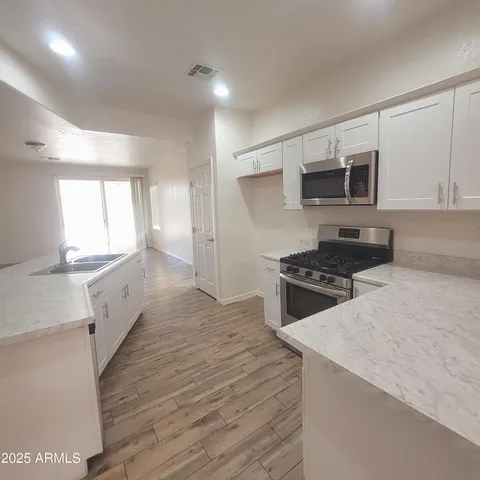 a kitchen with granite countertop a sink and a stove top oven