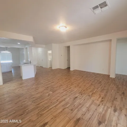 a view of an empty room and a kitchen