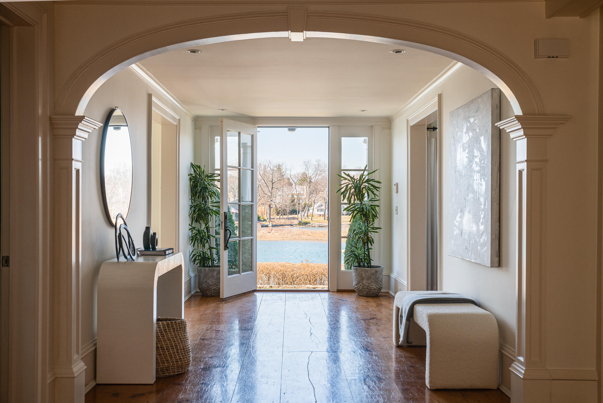 98 Pear Tree Point Road Darien, CT 06820 - Photo 3 of 42 a hallway with couches and large windows with wooden floor
