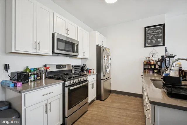 a kitchen with stainless steel appliances a stove microwave and refrigerator
