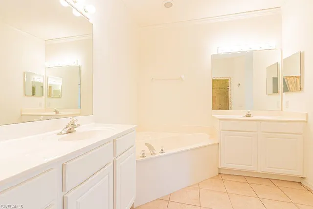 a spacious bathroom with a double vanity sink a mirror and a bathtub