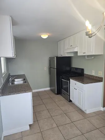 a kitchen with a sink a stove and cabinets