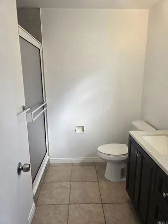 a bathroom with a granite countertop toilet and a sink