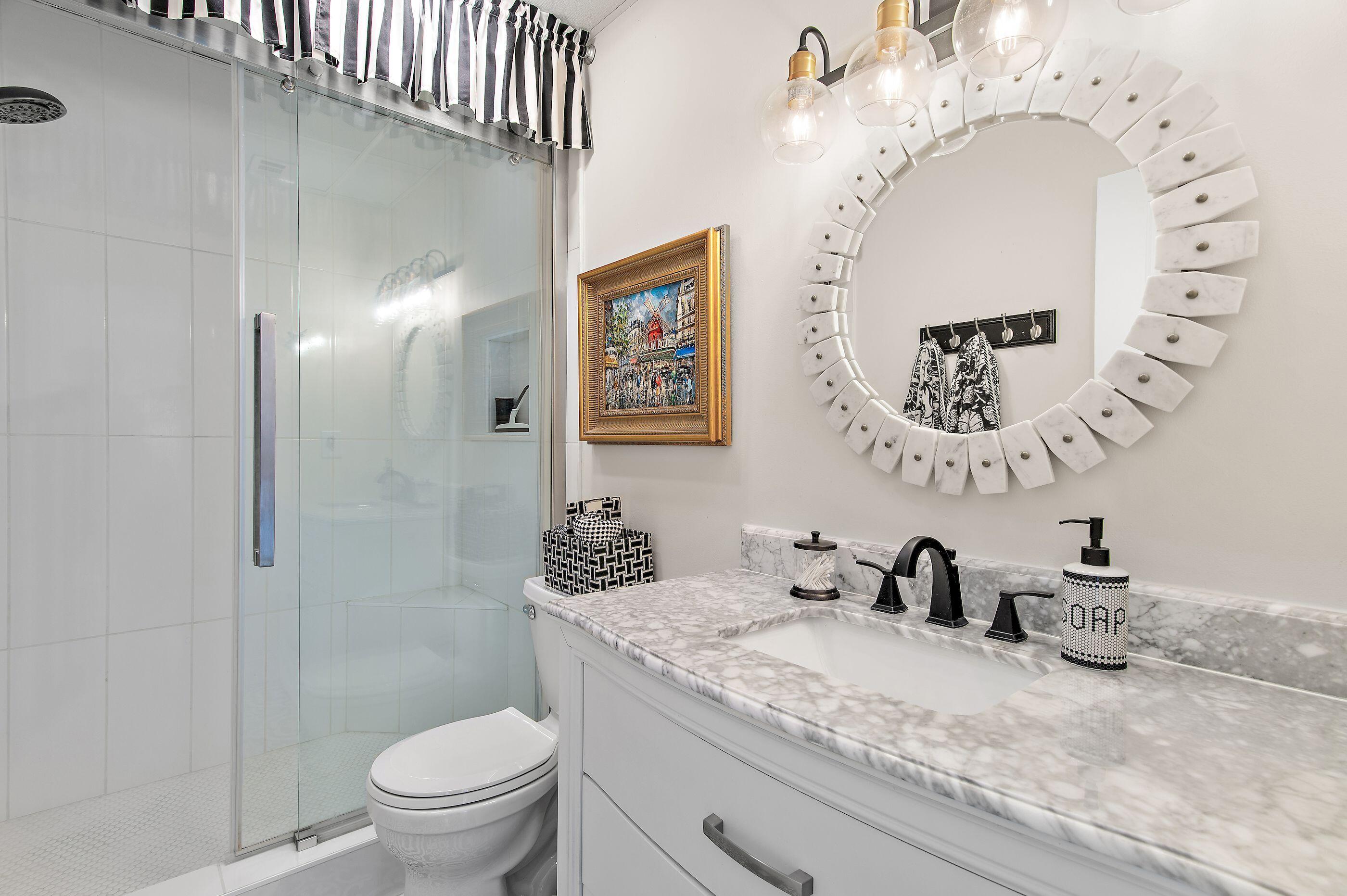 197 Durango Road, Unit 2B Destin, FL 32541 - Photo 15 of 29 a bathroom with a granite countertop sink a toilet and a mirror