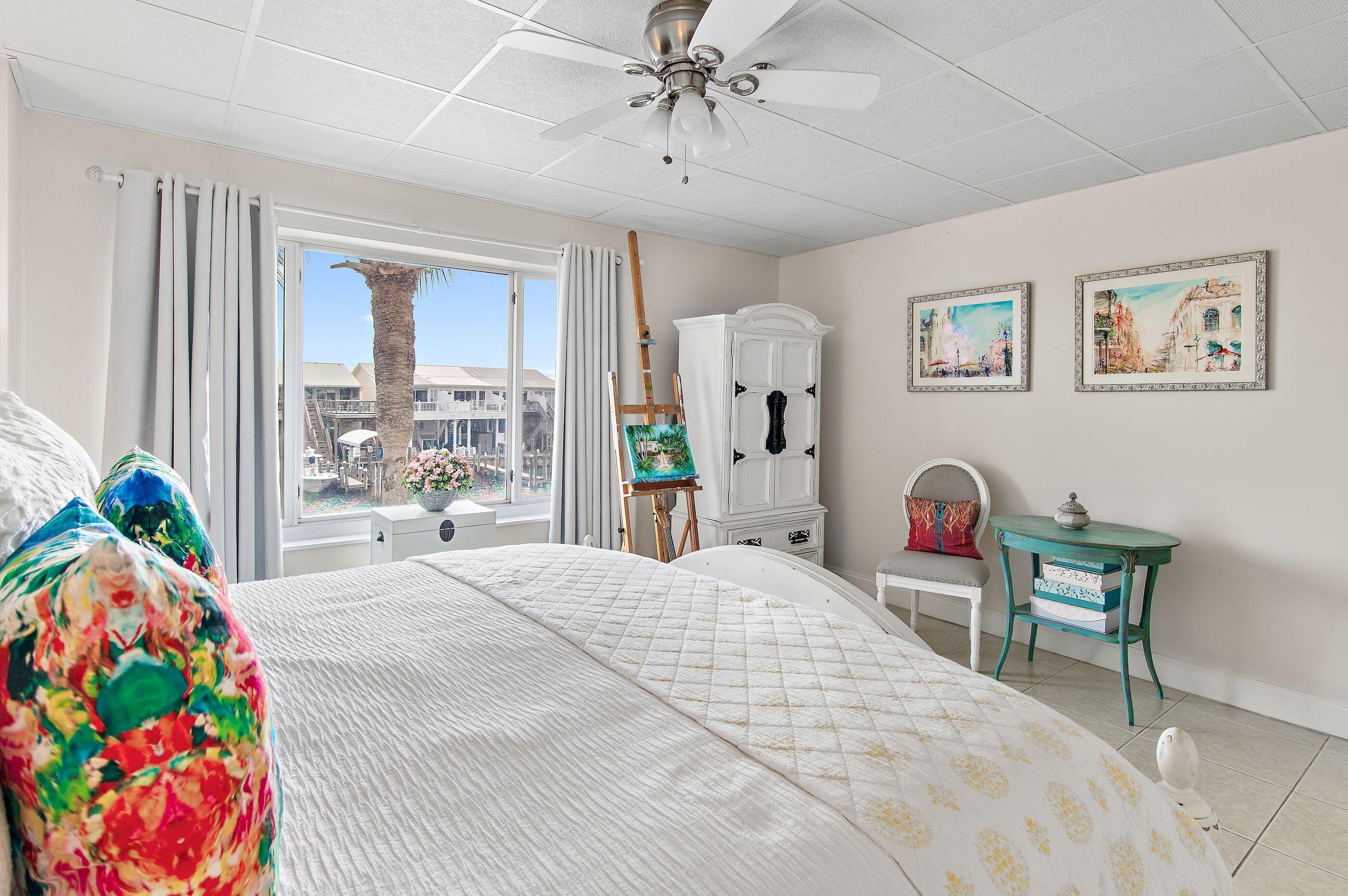 197 Durango Road, Unit 2B Destin, FL 32541 - Photo 16 of 29 a bedroom with a bed and a chandelier