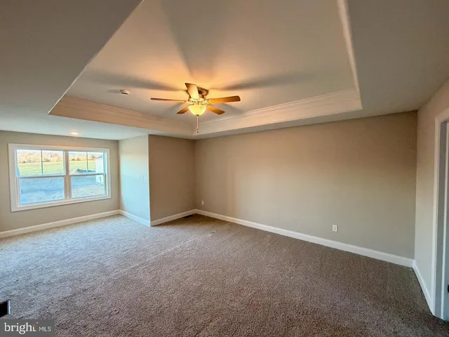 an empty room with a ceiling fan and window