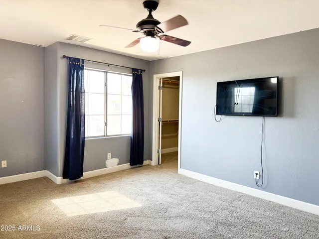 a view of an empty room with window and cabinet