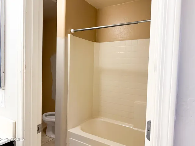 an empty room with closet and a chandelier fan