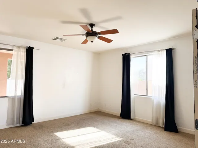 a view of a big room with wooden floor and a ceiling fan