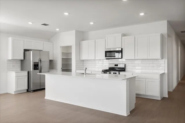 a view of a kitchen with refrigerator and window