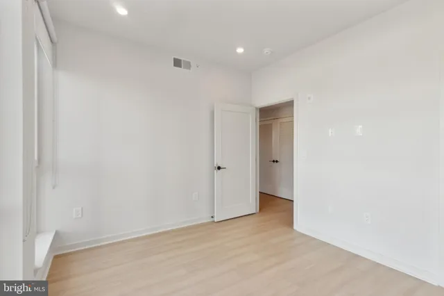 an empty room with wooden floor and a window