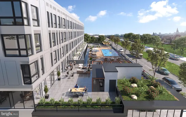 a large kitchen with stainless steel appliances a large counter top a stove and a refrigerator